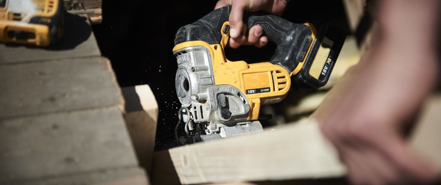 Udskæring i mørk træbjælke med stiksav