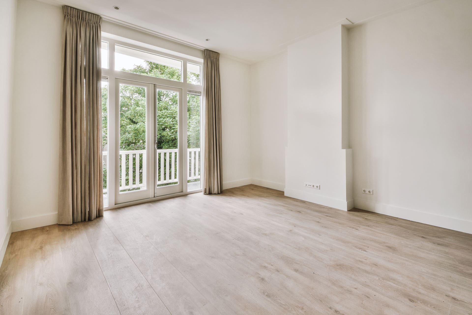 Nyt lyst trægulv og hvide vægge i færdigrenoveret stue